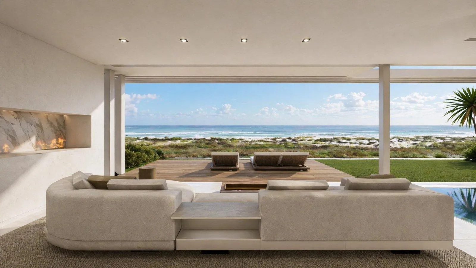 Living area facing the sea through full-height glazing